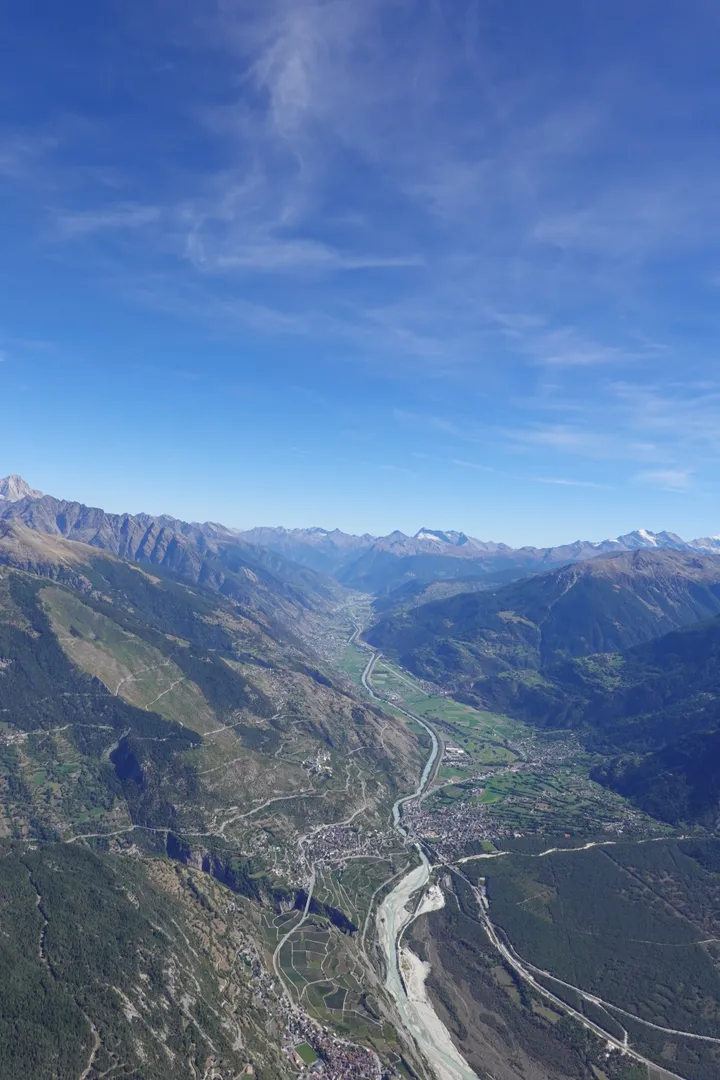 Blick aus der Luft über das Rhonetal, links und rechts bewaldete Hänge, weit hinten die Berge.